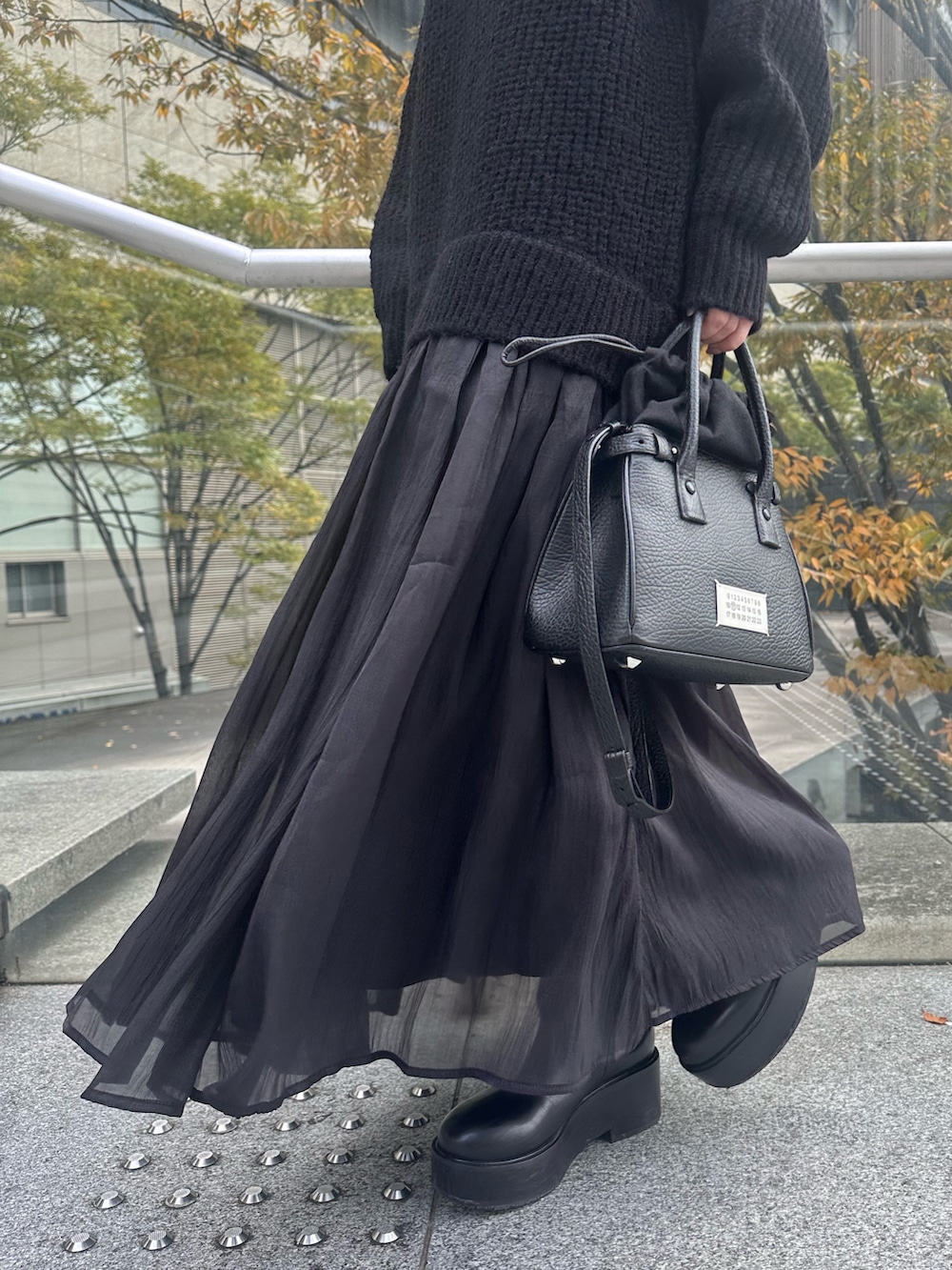 ブラック系のワンピース、ブラック系のショルダーバッグ、ブラック系のキャップを着用したレディースの秋コーディネートの8枚目の写真