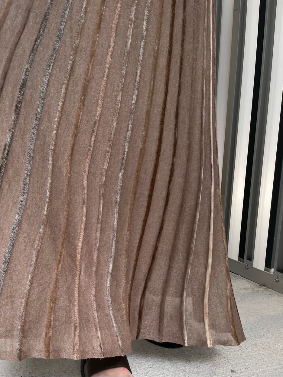 ブラウン系のスカート、ブラック系のニット/セーター、ブラウン系のサンダルを着用したレディースの夏コーディネートの7枚目の写真