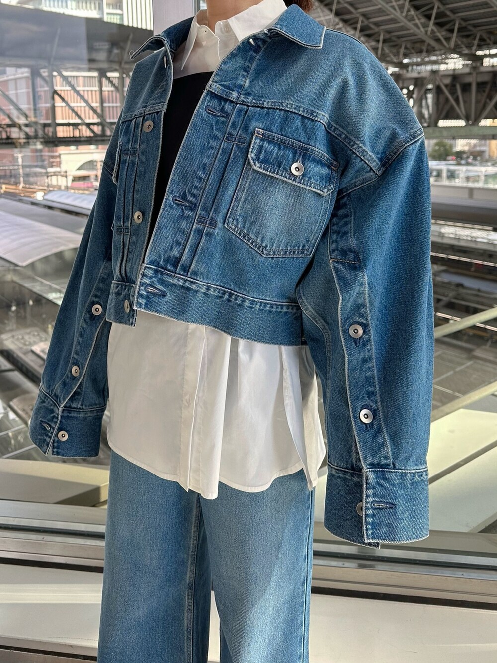 ブルー系のデニムジャケット、ブルー系のデニムパンツ、シルバー系のパンプスを着用したレディースの冬コーディネートの6枚目の写真