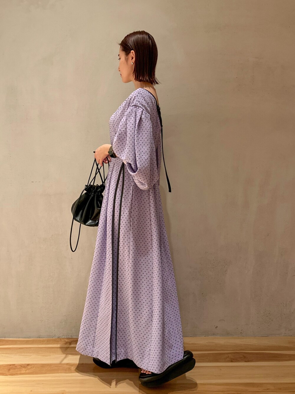 パープル系のワンピース、ベージュ系のテーラードジャケット、ブラック系のサンダルを着用したレディースの冬コーディネートの4枚目の写真