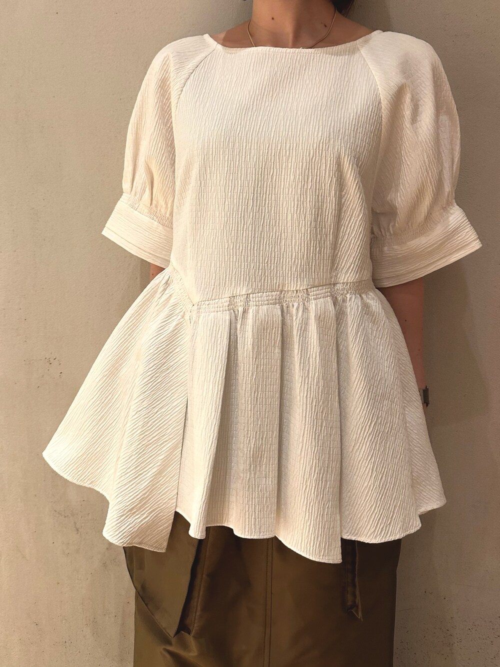 ブラウン系のスカート、ブラック系のスニーカー、ホワイト系のシャツ/ブラウスを着用したレディースの春コーディネートの5枚目の写真