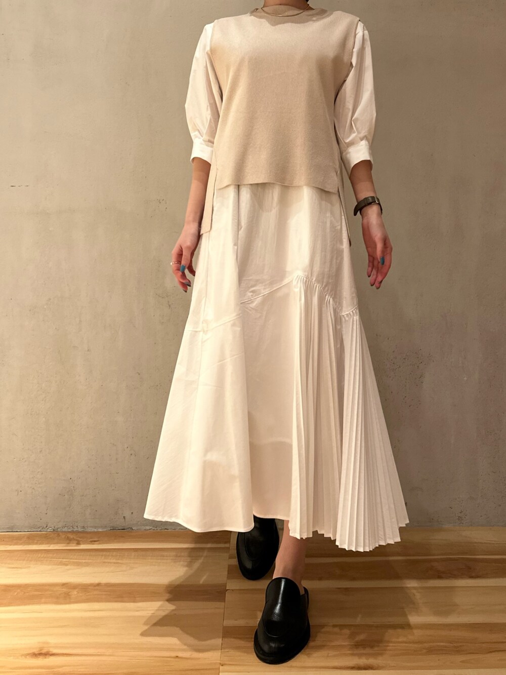 ホワイト系のワンピース、ブラック系のノーカラーコートを着用したレディースの春コーディネートの2枚目の写真