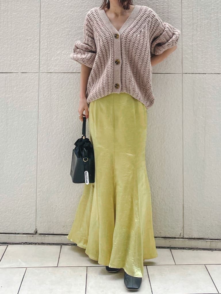 ブラック系のその他シューズ、ベージュ系のカーディガン/ボレロ、イエロー系のスカートを着用したレディースの冬コーディネートの2枚目の写真