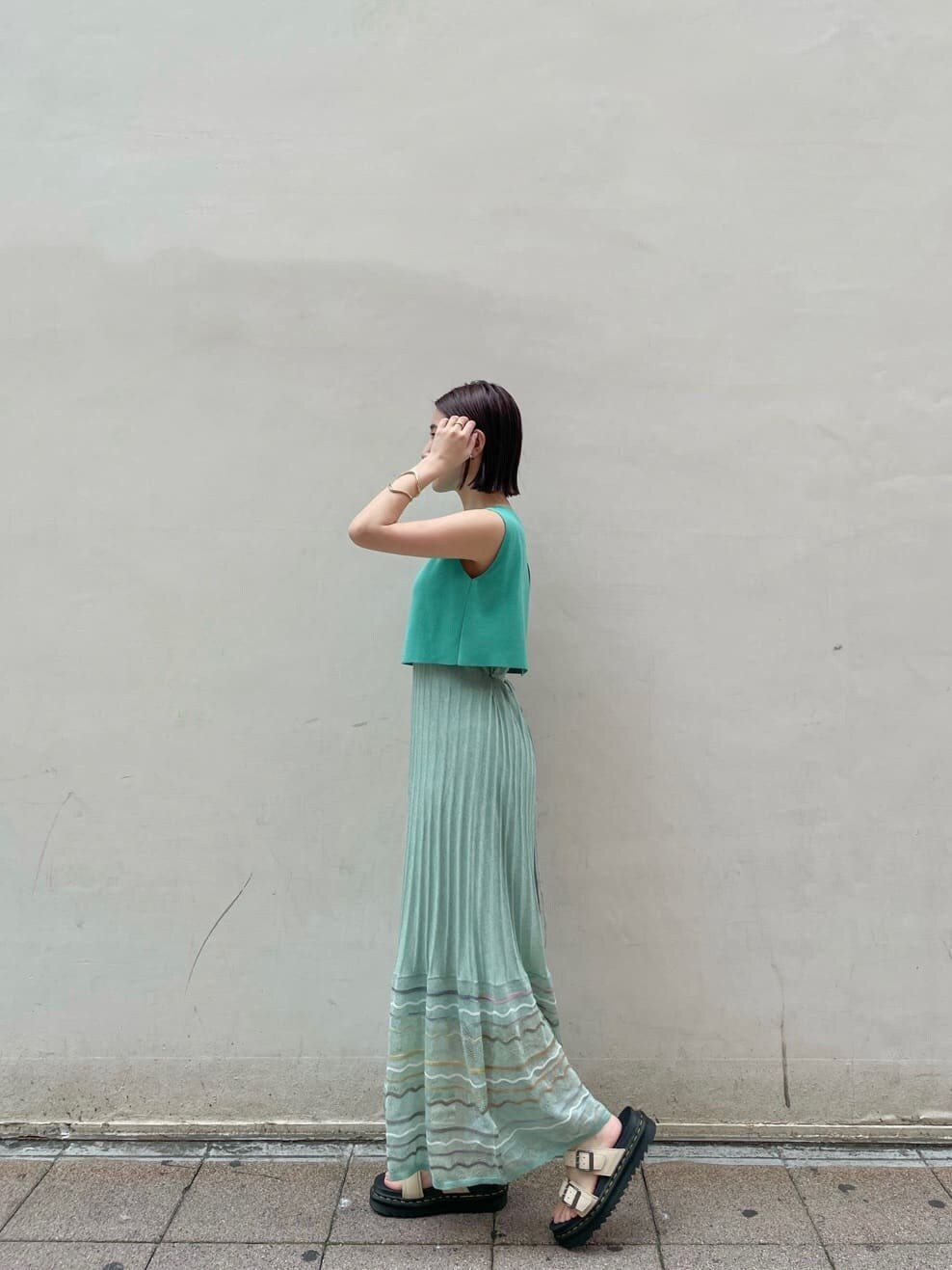 グリーン系のワンピース、ベージュ系のサンダルを着用したレディースの夏コーディネートの2枚目の写真