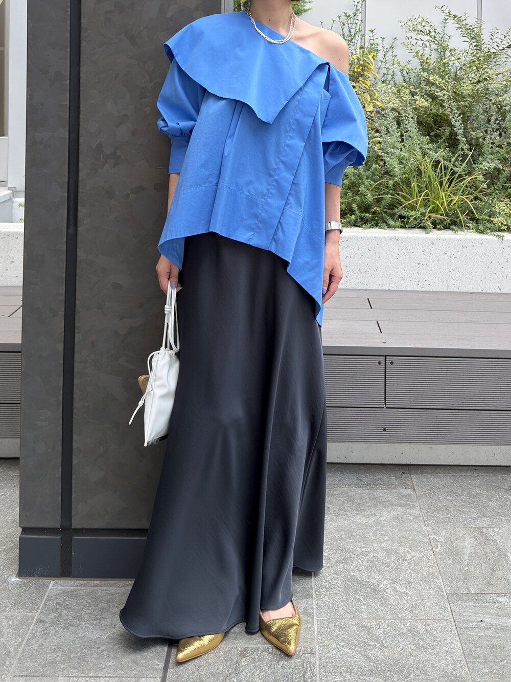 ブルー系のシャツ/ブラウス、グレー系のスカート、ゴールド系のネックレスを着用したレディースの夏コーディネートの6枚目の写真