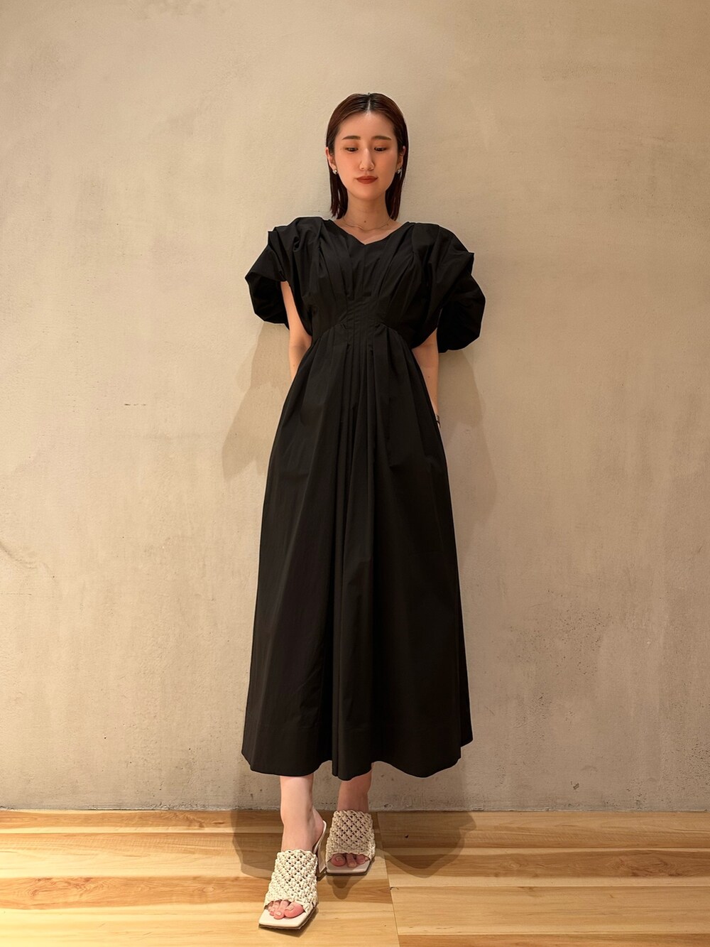 ブラック系のワンピースを着用したレディースの春コーディネートの2枚目の写真