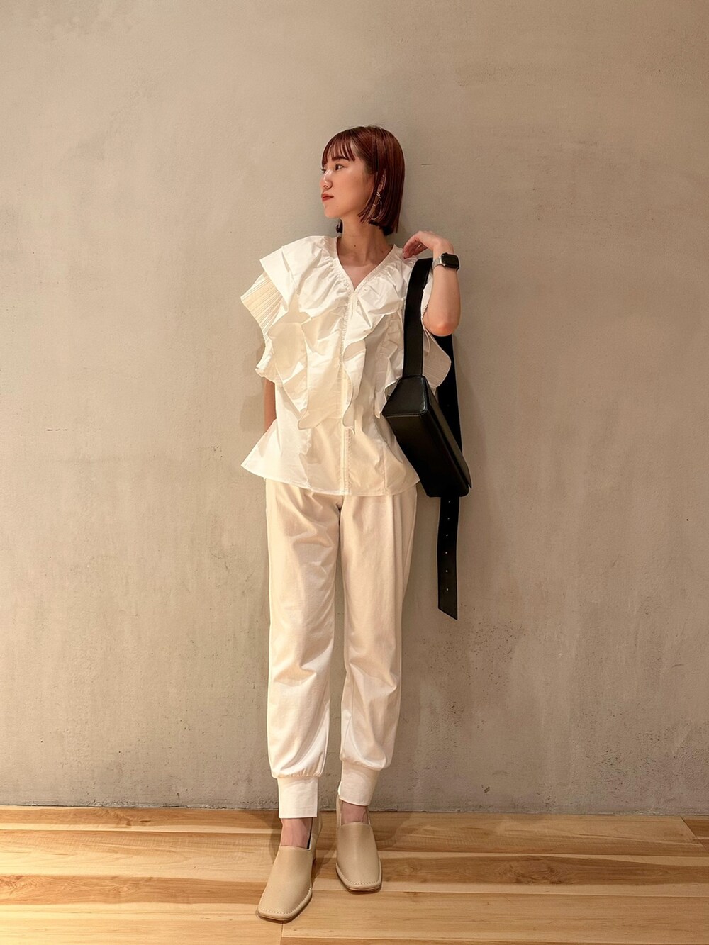 ベージュ系のブーティ、ホワイト系のシャツ/ブラウス、ブラック系のショルダーバッグを着用したレディースの夏コーディネートの2枚目の写真