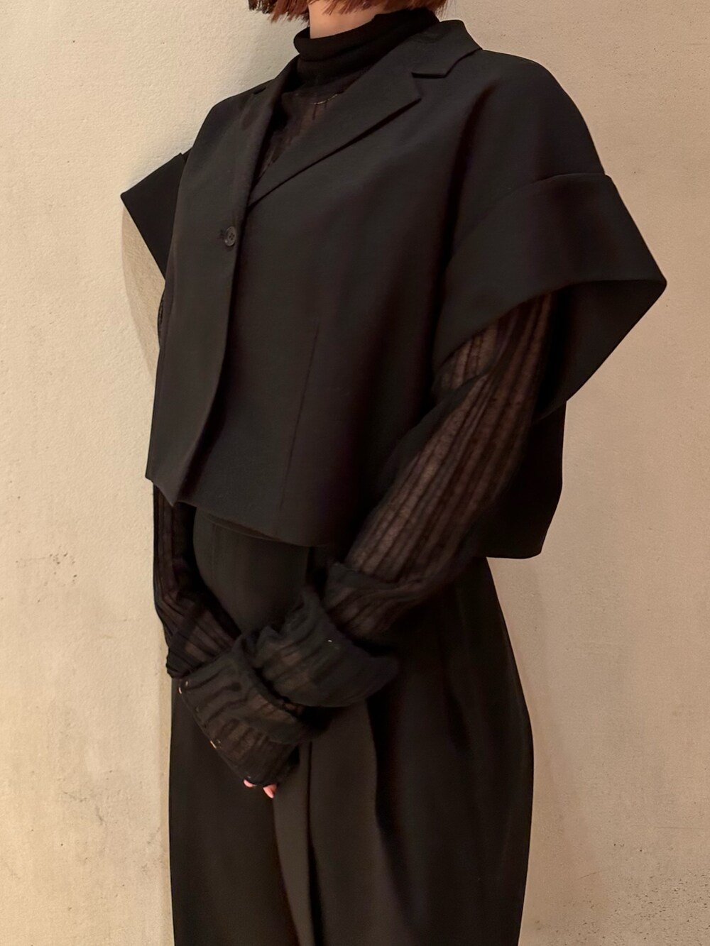 ブラック系のスラックス、ブラック系のニット/セーター、ブラック系のテーラードジャケットを着用したレディースの春コーディネートの6枚目の写真