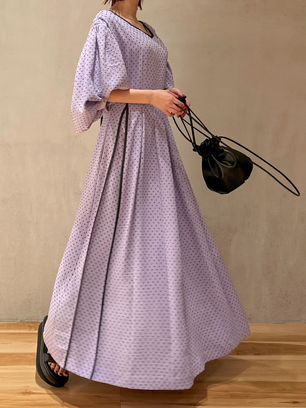 パープル系のワンピース、ベージュ系のテーラードジャケット、ブラック系のサンダルを着用したレディースの冬コーディネートの2枚目の写真