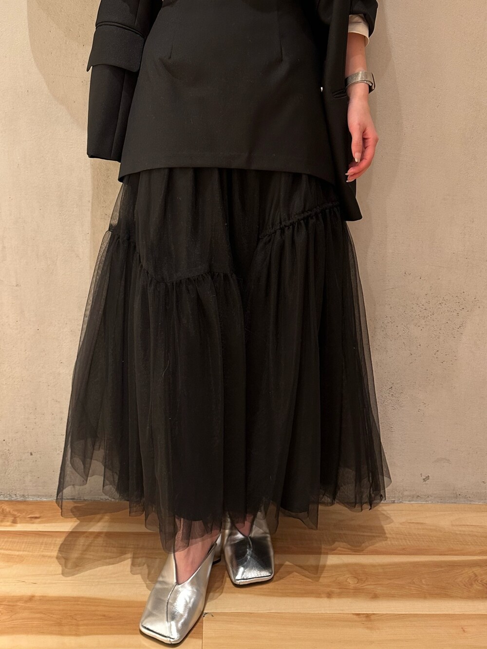 ブラック系のスカート、ブラック系のテーラードジャケット、ホワイト系のTシャツ/カットソーを着用したレディースの冬コーディネートの7枚目の写真