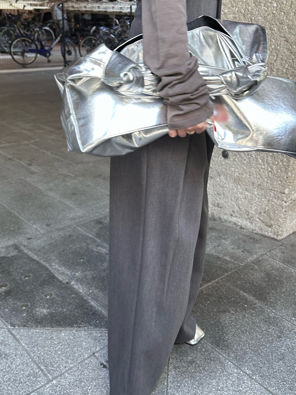 グレー系のニット/セーター、グレー系のその他パンツ、シルバー系のトートバッグを着用したレディースの夏コーディネートの9枚目の写真