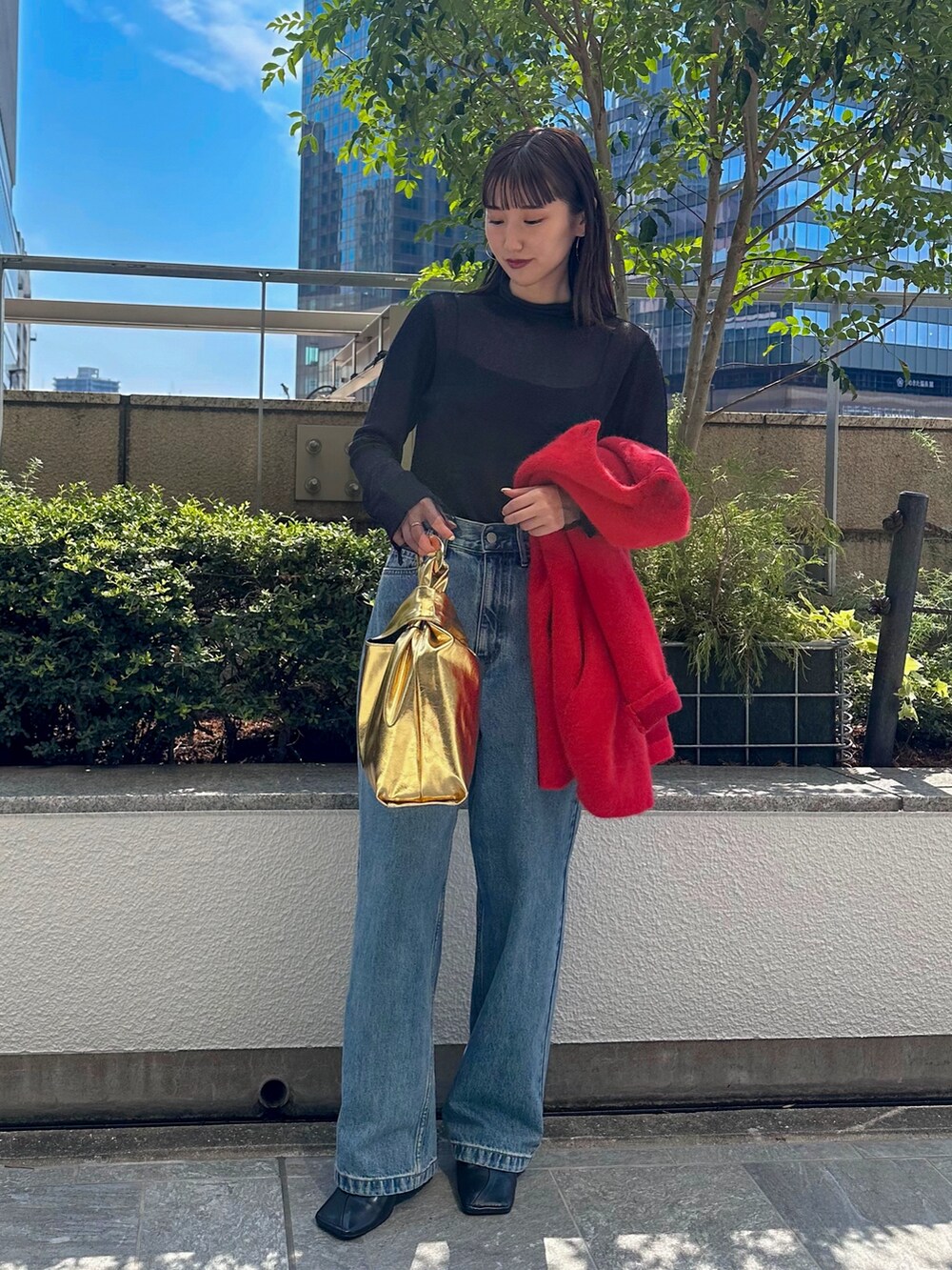 ブルー系のデニムパンツ、ブラック系のパンプス、ブラック系のニット/セーターを着用したレディースの夏コーディネートの2枚目の写真