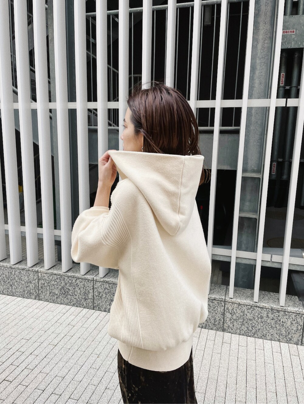 ブラウン系のスカート、ホワイト系のパーカーを着用したレディースの冬コーディネートの2枚目の写真