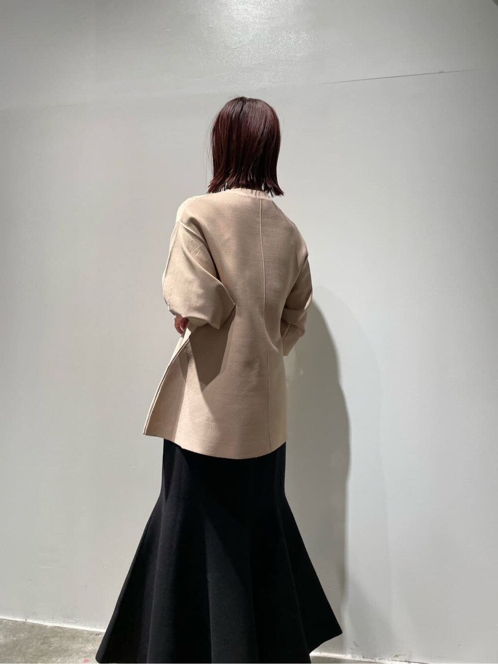 ベージュ系のニット/セーター、ブラウン系のノーカラーコート、ブラック系のブーツを着用したレディースの秋コーディネートの4枚目の写真