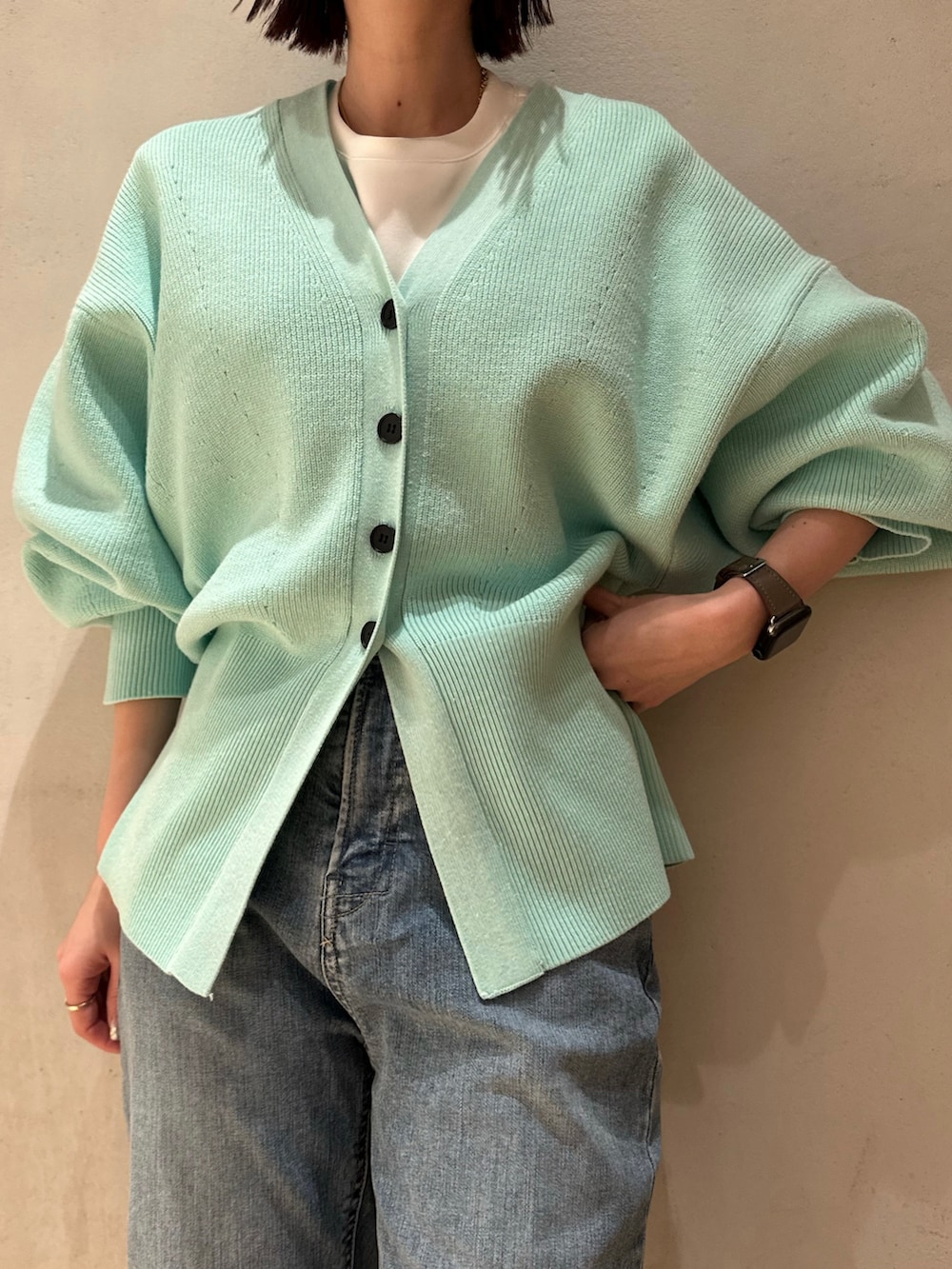 ブルー系のデニムパンツ、グリーン系のカーディガン/ボレロ、ホワイト系のTシャツ/カットソーを着用したレディースの冬コーディネートの3枚目の写真