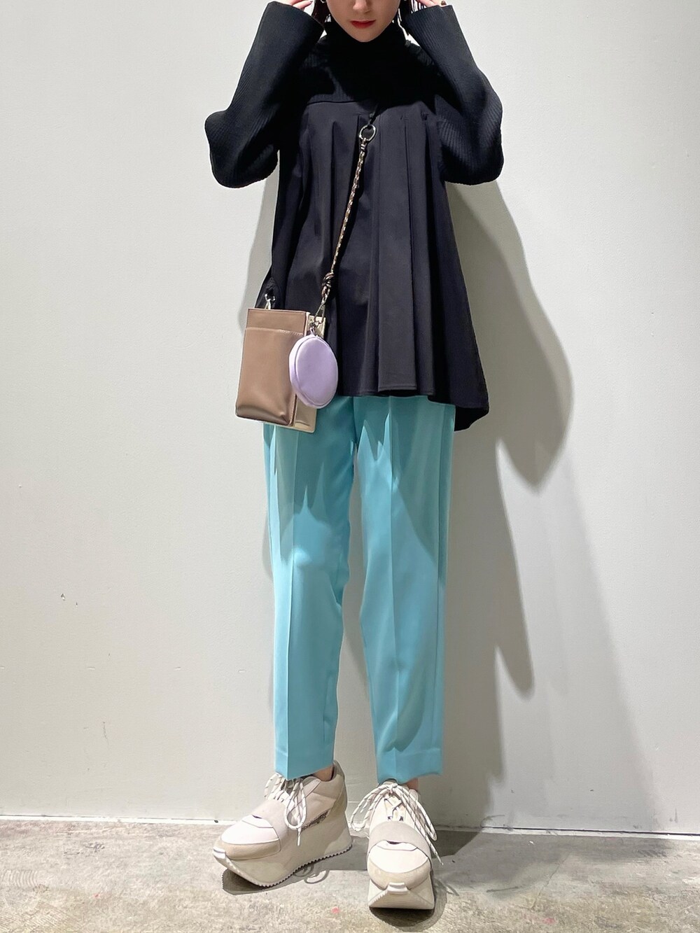 ホワイト系のニット/セーター、ブルー系のその他パンツ、ブラウン系のスニーカーを着用したレディースの冬コーディネートの2枚目の写真