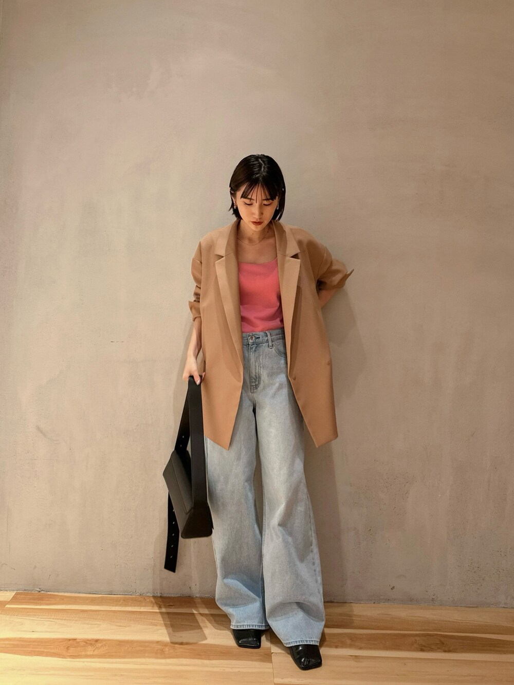 ブルー系のデニムパンツ、ブラック系のパンプス、ブラック系のショルダーバッグを着用したレディースの冬コーディネートの3枚目の写真