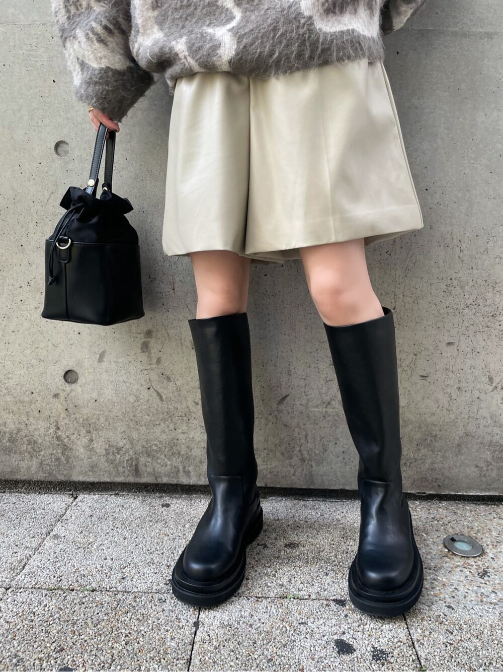 ブラック系のブーツ、ホワイト系のその他パンツ、ブラック系のハンドバッグを着用したレディースの秋コーディネートの7枚目の写真