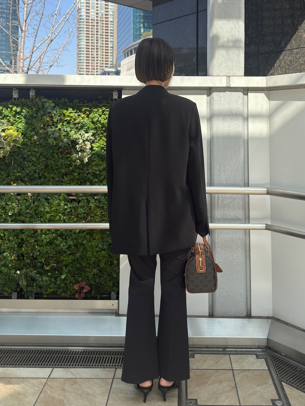 ブラック系のノーカラージャケット、ブラック系のその他パンツ、ブラック系のパンプスを着用したレディースの冬コーディネートの3枚目の写真