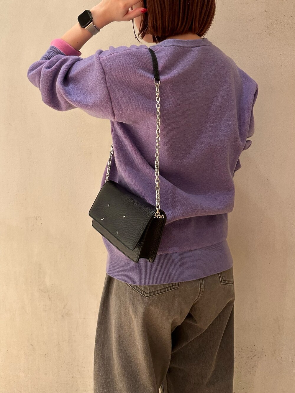 パープル系のニット/セーター、グレー系のデニムパンツ、ブラック系のパンプスを着用したレディースの夏コーディネートの4枚目の写真