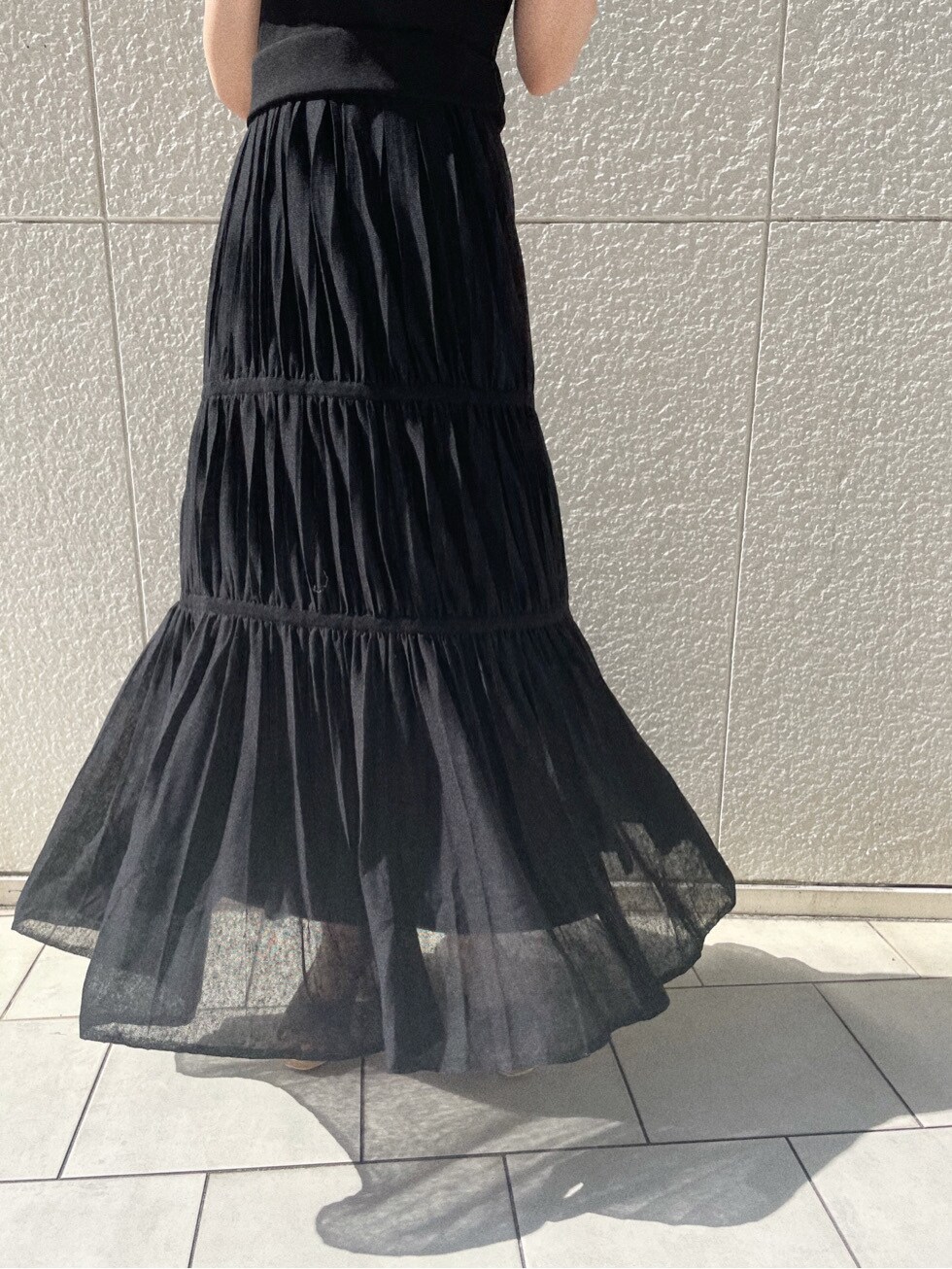 ブラウン系のパンプス、ブラック系のワンピース、ホワイト系のニット/セーターを着用したレディースの春コーディネートの6枚目の写真