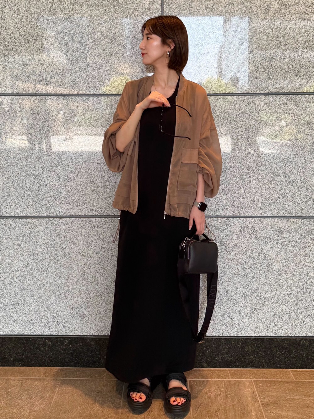 ベージュ系のブルゾン、ブラック系のワンピース、ブラック系のサングラスを着用したレディースの夏コーディネートの2枚目の写真