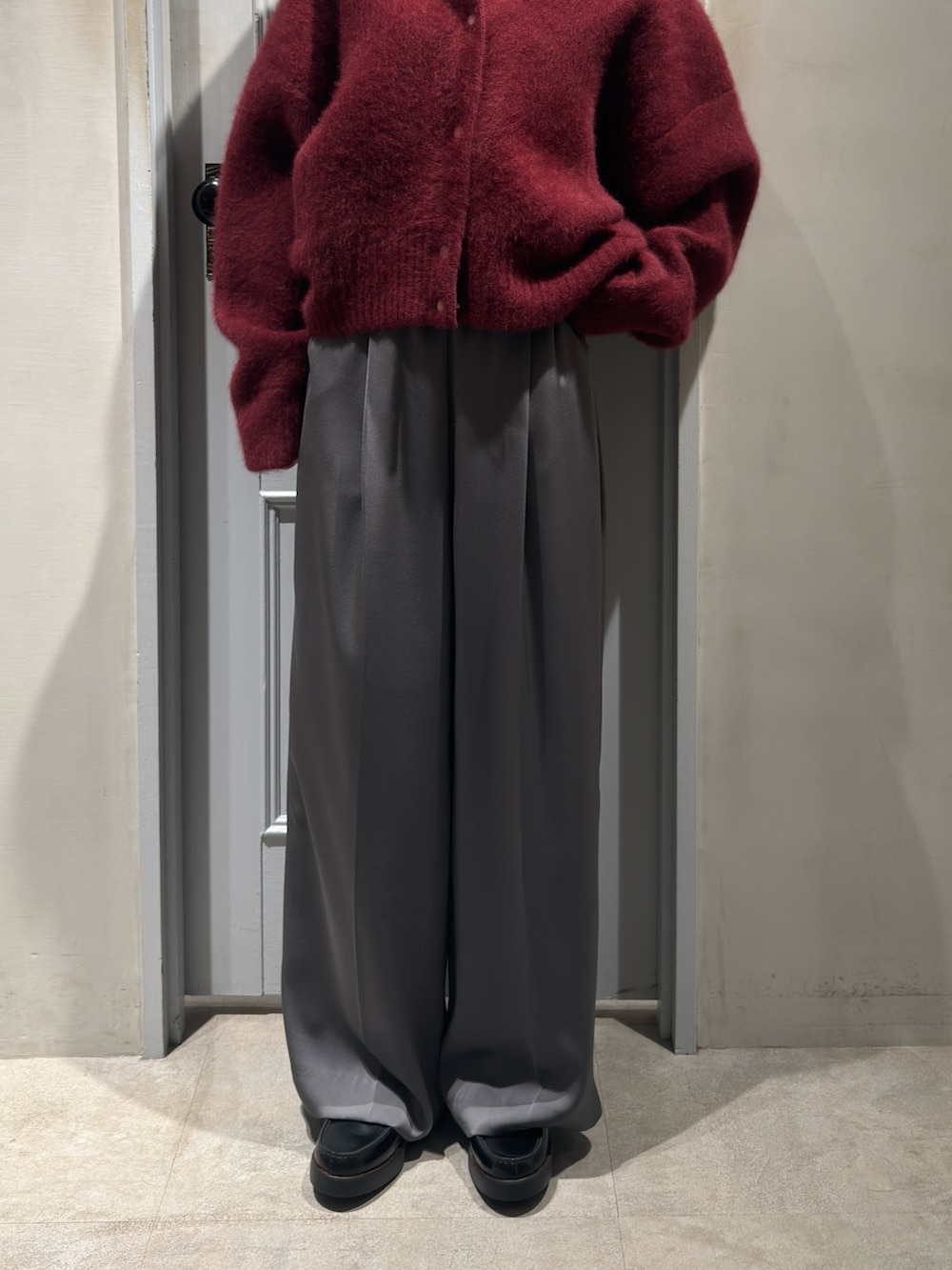 レッド系のカーディガン/ボレロ、グレー系のその他パンツ、ブラック系のローファーを着用したレディースの冬コーディネートの6枚目の写真