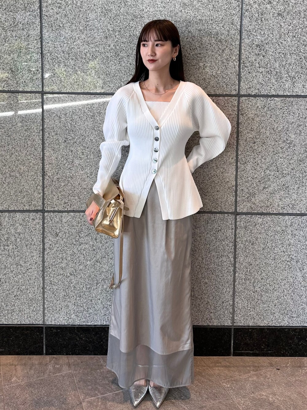ホワイト系のカーディガン/ボレロ、ベージュ系のスカート、シルバー系のサンダルを着用したレディースの秋コーディネートの2枚目の写真