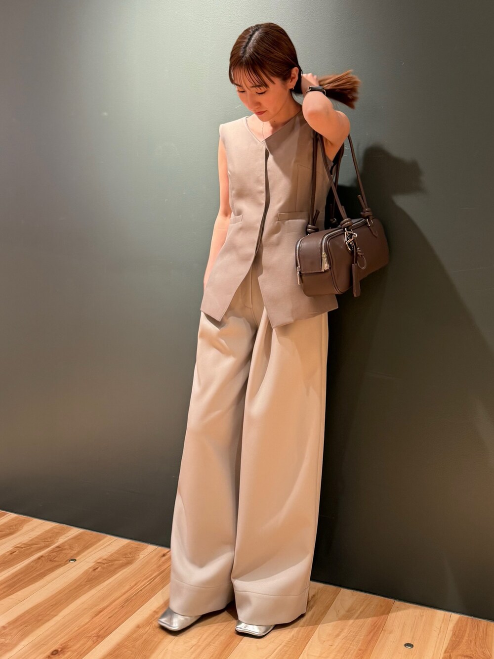 ベージュ系のベスト、ホワイト系のその他パンツ、ブラック系のボストンバッグを着用したレディースの冬コーディネートの3枚目の写真