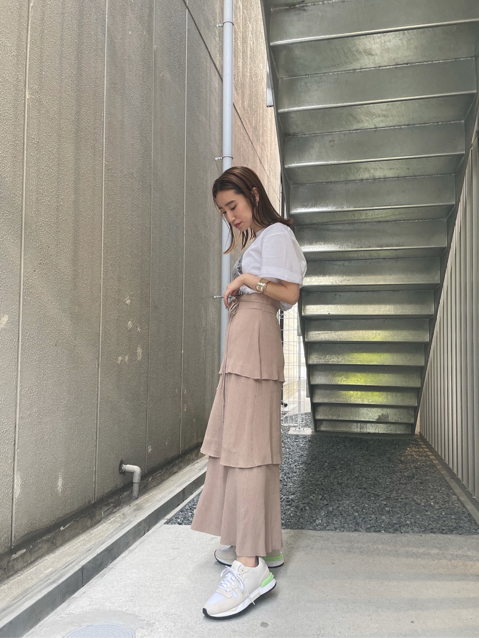 ホワイト系のスニーカー、ベージュ系のスカート、ホワイト系のTシャツ/カットソーを着用したレディースの春コーディネートの4枚目の写真