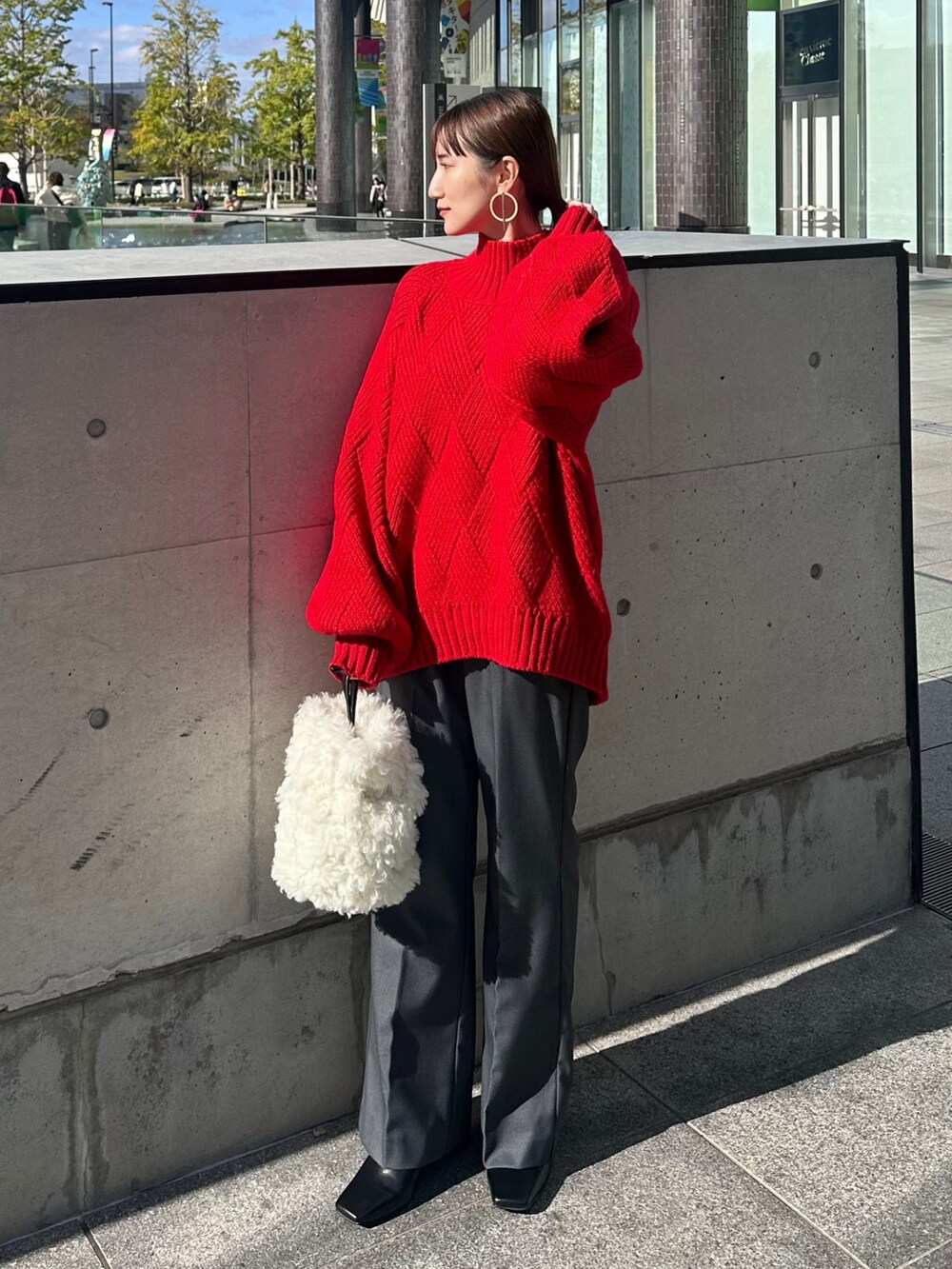 ブラック系のその他アウター、レッド系のニット/セーター、グレー系のその他パンツを着用したレディースの冬コーディネートの5枚目の写真