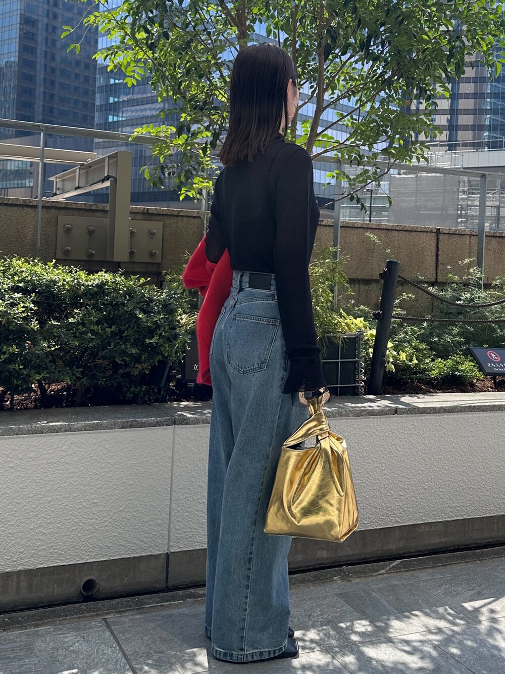 ブルー系のデニムパンツ、ブラック系のパンプス、ブラック系のニット/セーターを着用したレディースの夏コーディネートの3枚目の写真