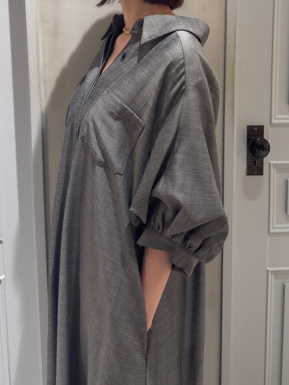 ブラック系のパンプス、グレー系のワンピースを着用したレディースの春コーディネートの3枚目の写真