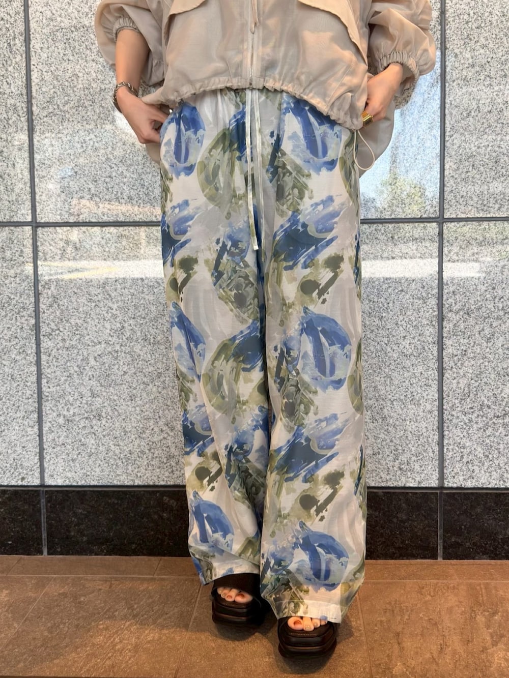 ベージュ系のブルゾン、ブルー系のその他パンツ、ブラウン系のサンダルを着用したレディースの春コーディネートの5枚目の写真