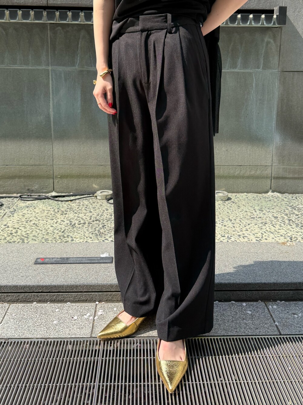 ブラック系のテーラードジャケット、ブラック系のその他パンツ、ゴールド系のサンダルを着用したレディースの春コーディネートの7枚目の写真