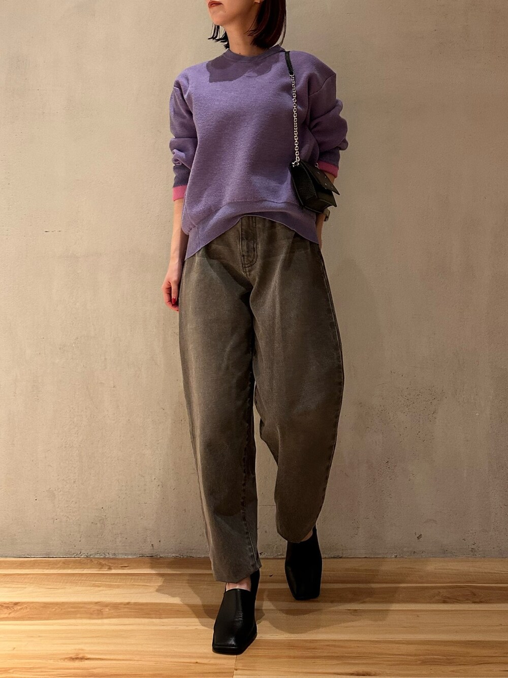 パープル系のニット/セーター、グレー系のデニムパンツ、ブラック系のパンプスを着用したレディースの夏コーディネートの3枚目の写真