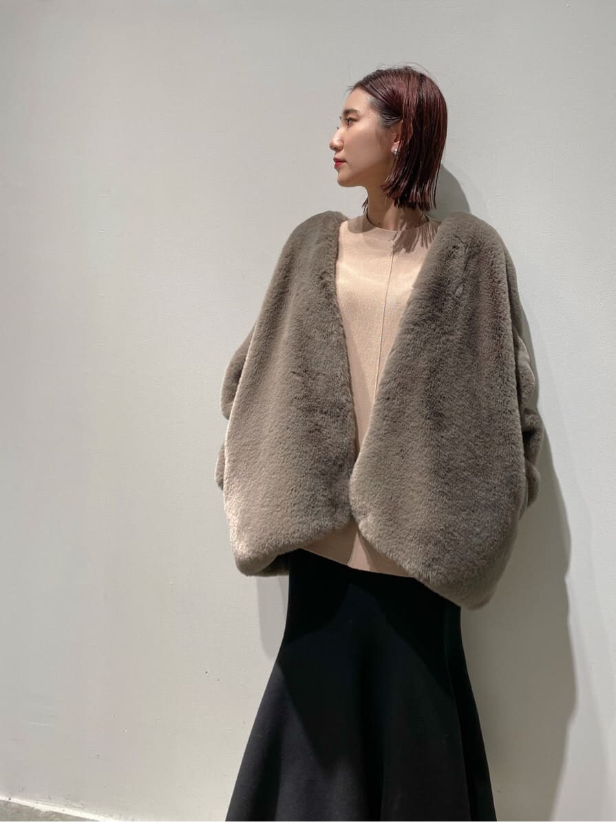 ベージュ系のニット/セーター、ブラウン系のノーカラーコート、ブラック系のブーツを着用したレディースの秋コーディネートの6枚目の写真