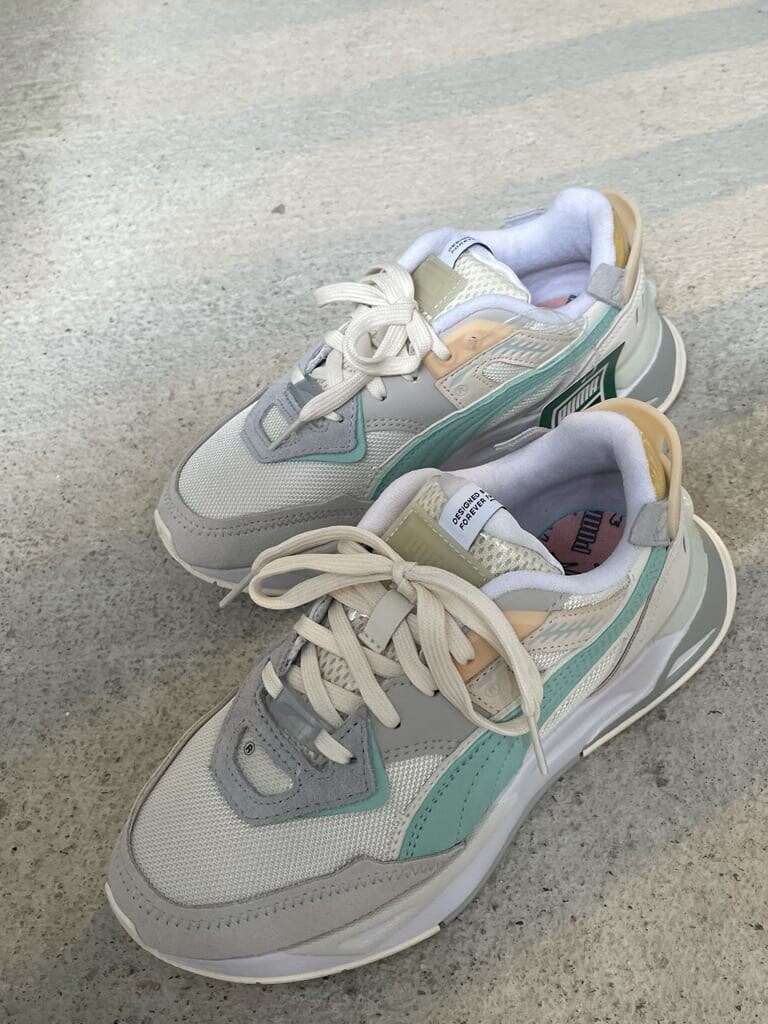 グレー系のスカート、ホワイト系のスニーカー、ブラック系のニット/セーターを着用したレディースの夏コーディネートの6枚目の写真