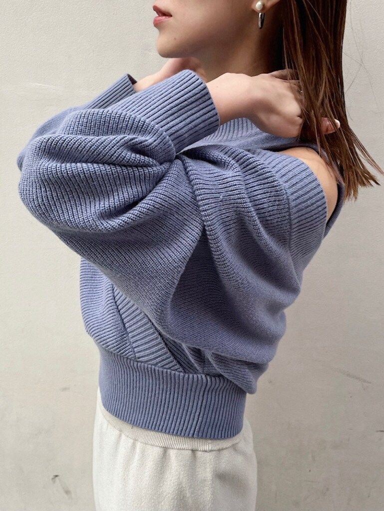 グレー系のスカート、ブルー系のニット/セーターを着用したレディースの冬コーディネートの2枚目の写真