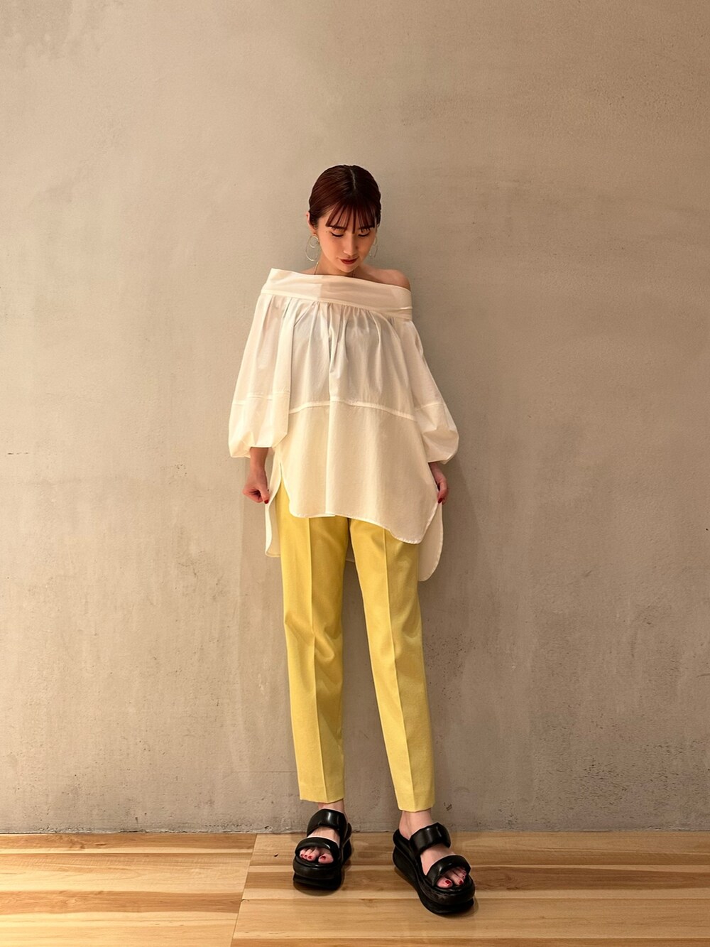 ホワイト系のシャツ/ブラウス、イエロー系のその他パンツ、ブラック系のサンダルを着用したレディースの夏コーディネートの2枚目の写真
