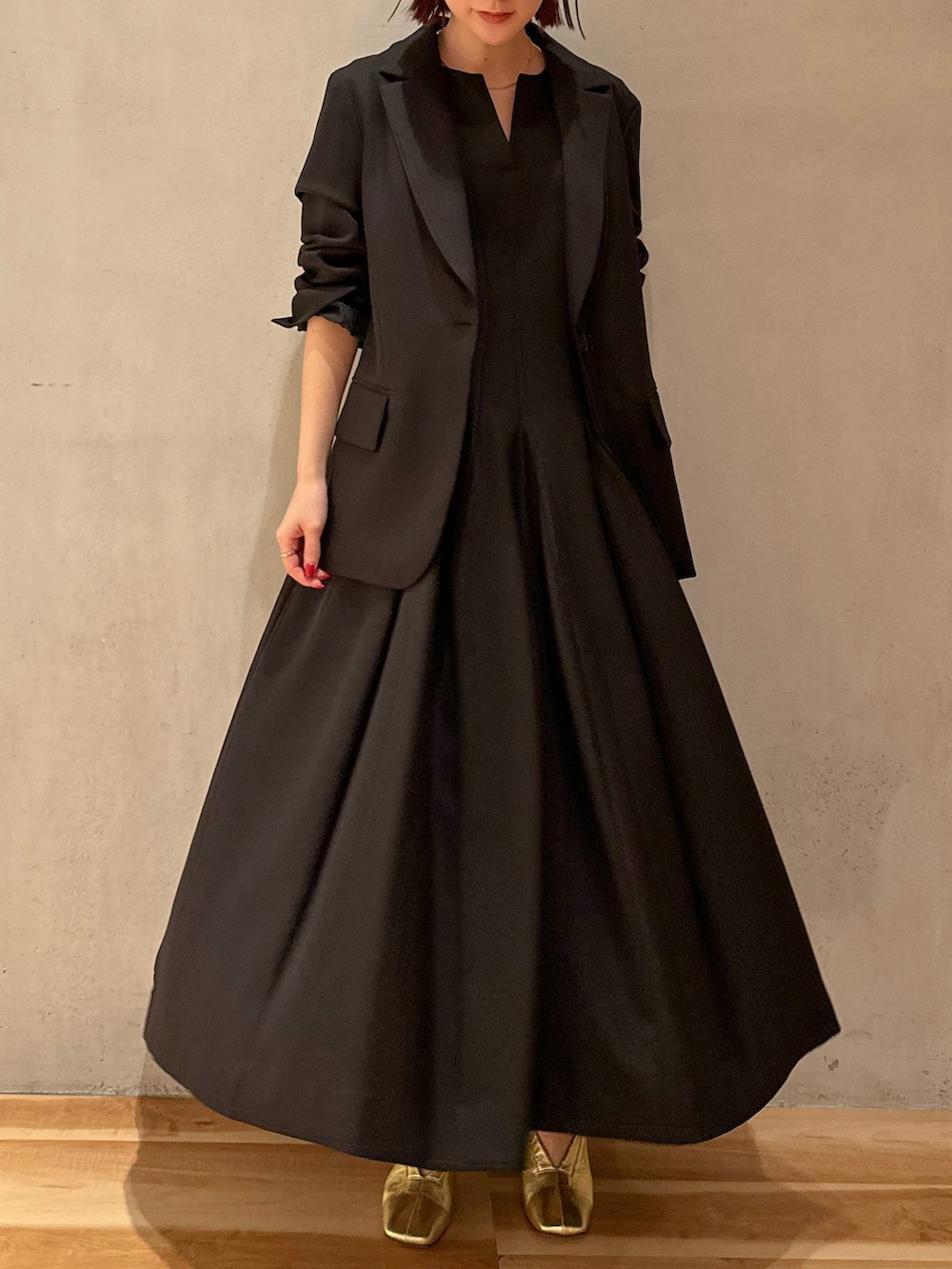 ブラック系のテーラードジャケット、ブラック系のワンピースを着用したレディースの冬コーディネートの3枚目の写真