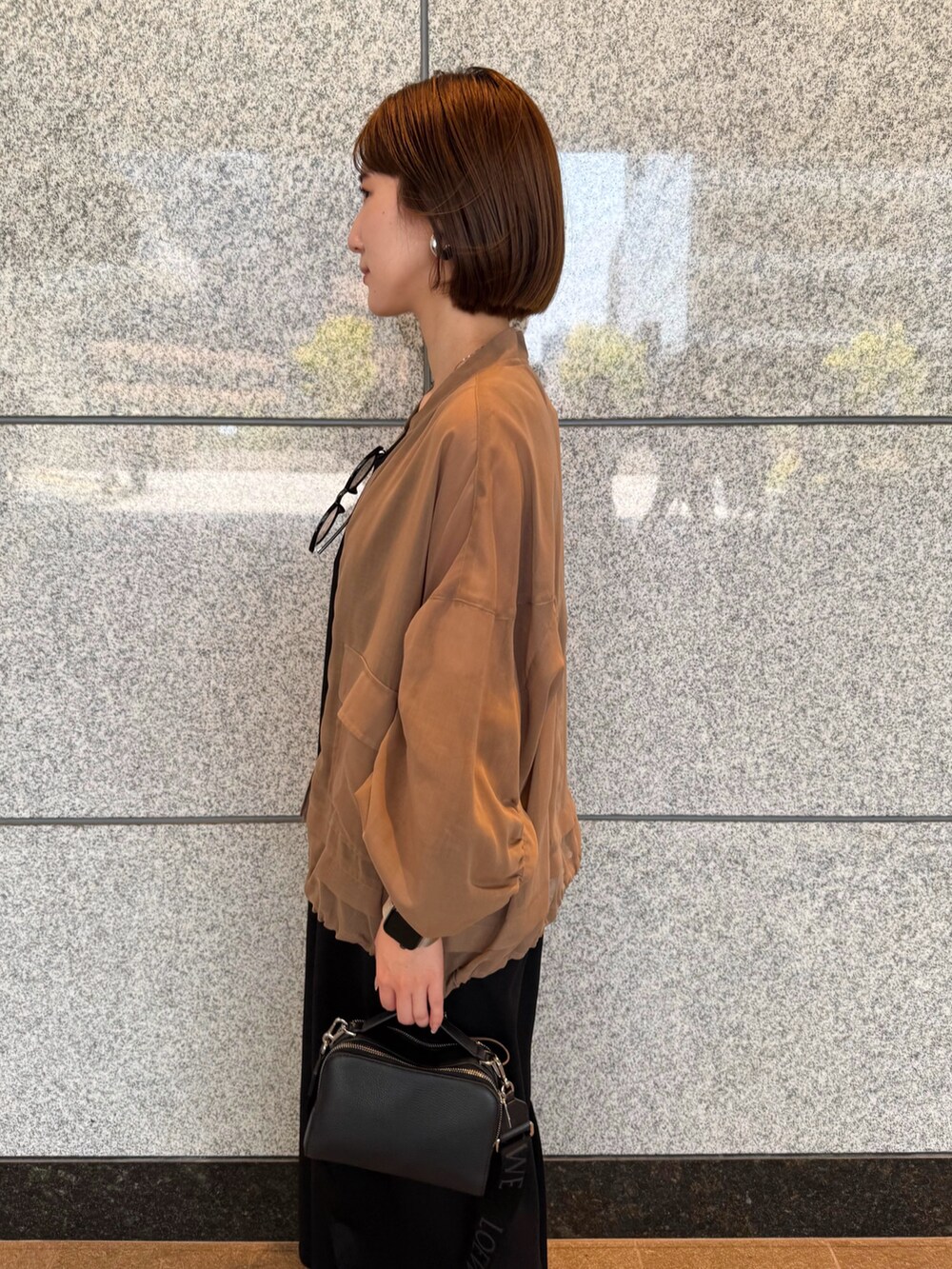 ベージュ系のブルゾン、ブラック系のワンピース、ブラック系のサングラスを着用したレディースの夏コーディネートの7枚目の写真