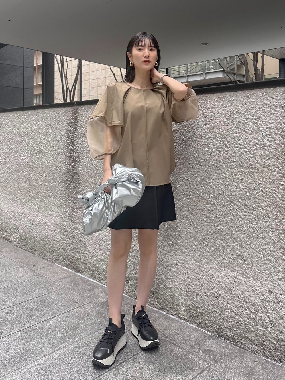 ベージュ系のシャツ/ブラウス、ブラック系のその他パンツ、シルバー系のショルダーバッグを着用したレディースの春コーディネートの2枚目の写真