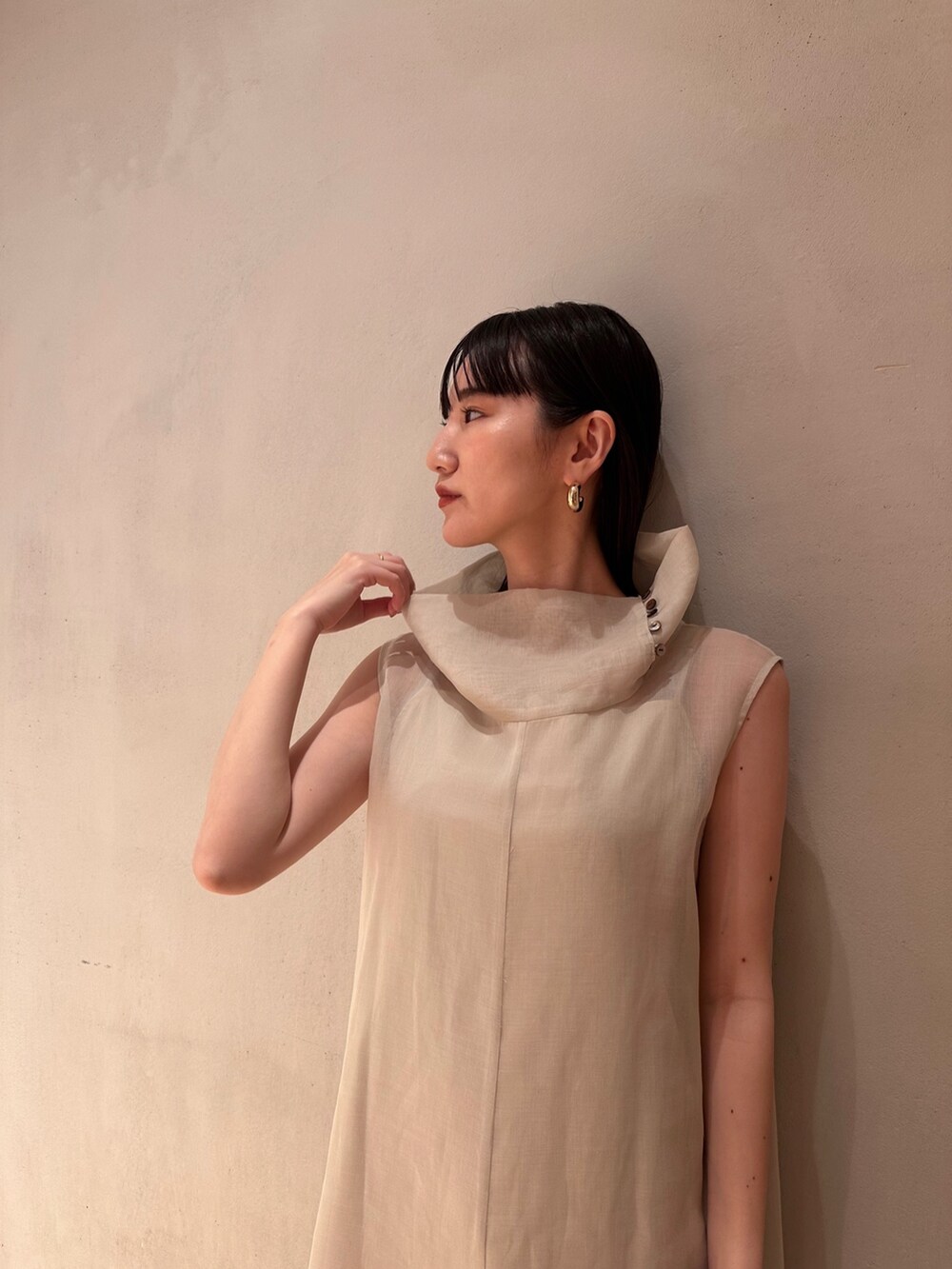 ベージュ系のワンピース、ゴールド系のパンプスを着用したレディースの夏コーディネートの4枚目の写真