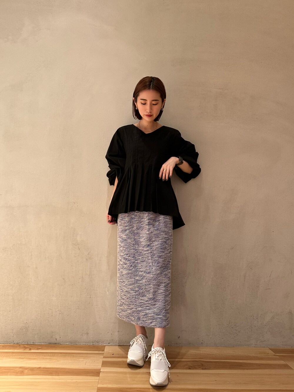 ブラック系のシャツ/ブラウス、ホワイト系のスニーカー、ブルー系のスカートを着用したレディースの春コーディネートの2枚目の写真