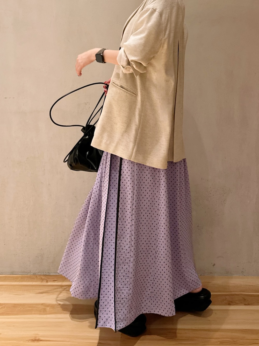 パープル系のワンピース、ベージュ系のテーラードジャケット、ブラック系のサンダルを着用したレディースの冬コーディネートの9枚目の写真