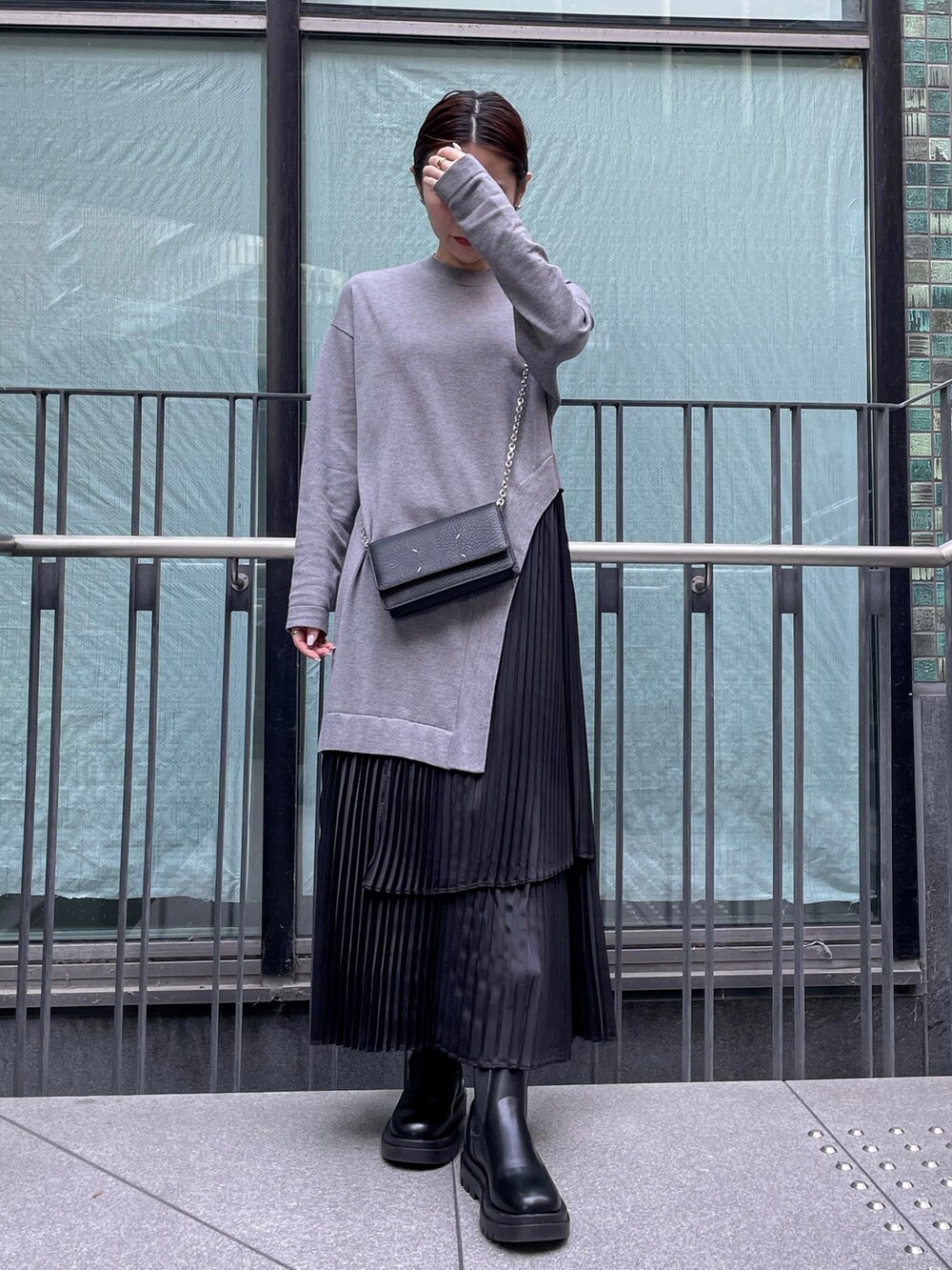 グレー系のワンピース、ブラック系のダウンジャケット/コート、ブラック系の財布を着用したレディースの冬コーディネートの3枚目の写真