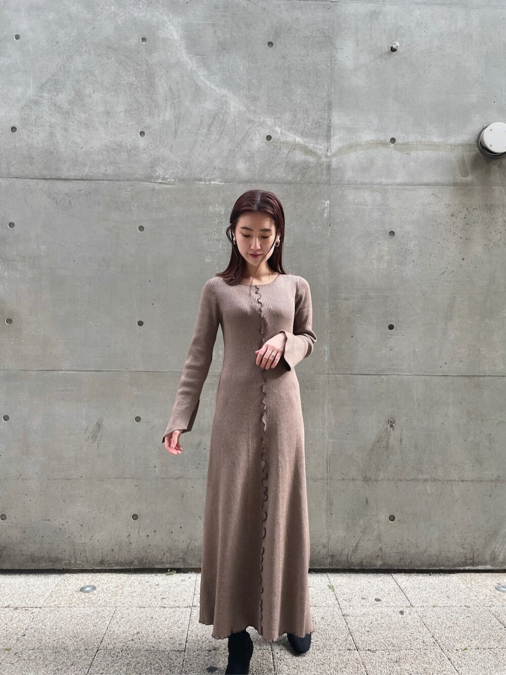 ベージュ系のワンピース、レッド系のパーカーを着用したレディースの冬コーディネートの5枚目の写真