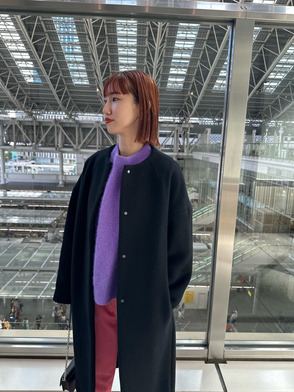 ブラック系のノーカラーコート、ブラック系のショルダーバッグ、ベージュ系のパンプスを着用したレディースの秋コーディネートの4枚目の写真