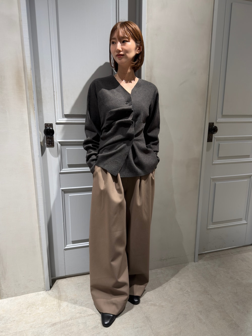 グレー系のニット/セーター、ブラウン系のその他パンツを着用したレディースの冬コーディネートの2枚目の写真